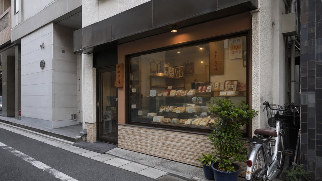 路地に面した小さな和菓子店の一枚窓。透明な状態と、本日のおすすめを投影した状態のイメージ